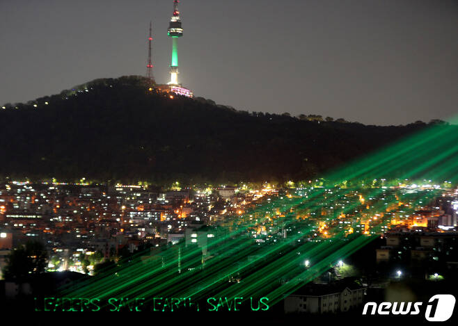 그린피스 회원들이 서울 남산에 온실가스 감축 노력을 촉구하는 레이저빔 퍼포먼스를 하고 있다.2021.4.21/뉴스1 © News1 황기선 기자