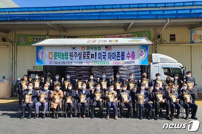 25일 원주 문막농협 미곡종합처리장에서 열린 토토미(원주 쌀 브랜드)의 미국 아마존몰 판매를 위한 수출선적식에서 NH농협무역 김재기 대표이사, 문막농협 한창진 조합장, 원주시 농업기술센터 김기준 소장(앞줄 왼쪽 다섯번째부터) 등 참석자들이 기념 촬영하고 있다.© 뉴스1