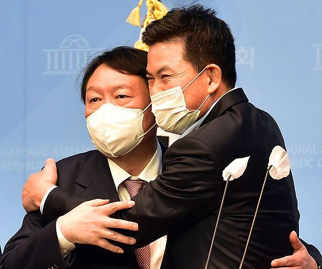 국민의힘 대선 주자인 윤석열(왼쪽) 전 검찰총장이 24일 국회 소통관에서 캠프 공동선대위원장으로 영입한 김태호 의원을 포옹하고 있다. /남강호 기자