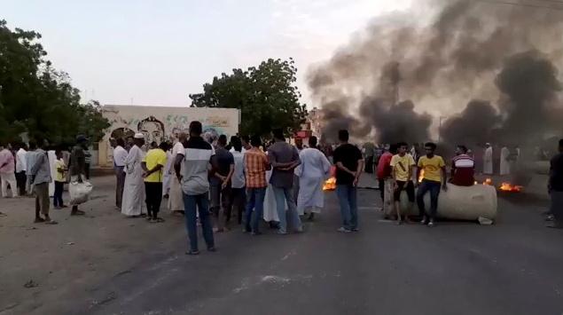 쿠데타 시도가 보고된 북아프리카 수단의 수도 하르툼에서 25일 불이 난 거리 주변에 사람들이 모여있다. 하르툼=로이터 연합뉴스
