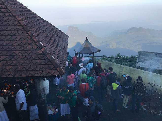 스리파다 종탑의 아래쪽에서 순례객들이 향을 피우고 참배하고 있다.