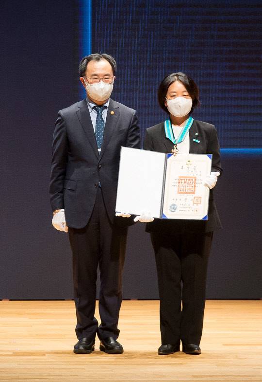 송현주 코웨이 디자인센터장(오른쪽)과 문승욱 산업통상자원부 장관이 산업훈장 수여 후 기념촬영을 하고 있다. <코웨이 제공>