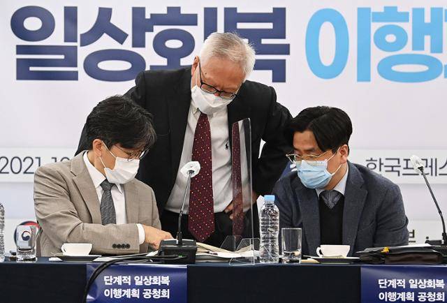 25일 서울 중구 한국프레스센터에서 열린 '코로나19 단계적 일상회복 이행계획 공청회'에 참석한 박건희(왼쪽부터) 경기도 감염병관리지원단장과 이윤성 한국보건의료인국가시험원장, 이재갑 한림대 의대 교수가 공청회 시작 전 대화를 하고 있다. 서재훈 기자