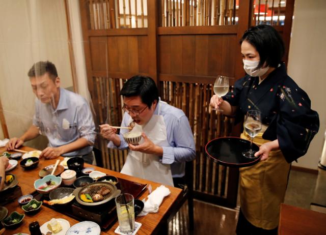 일본 전역에서 긴급사태 선언이 해제된 1일, 도쿄의 한 음식점에서 손님들이 식사하면서 주류를 주문해 마시고 있다. 25일부터는 도쿄와 수도권 3현에서 영업시간 제한도 해제됐다. 도쿄=로이터 연합뉴스