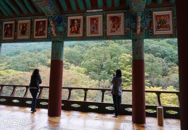 표충사 우화루 기둥 사이로 보이는 재약산 기슭에 가을 색이 물들고 있다.