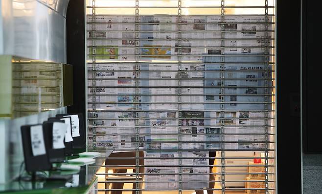 대장동 개발 로비·특혜 의혹 사건을 수사 중인 검찰이 지난 21일 성남시청 시장실과 비서실을 압수수색하는 가운데, 성남시 관계자들이 비서실 문을 신문지로 가리고 있는 모습. [연합]