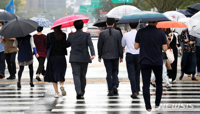 [서울=뉴시스] 이영환 기자 = 가을비가 내리고 있는 지난 8일 오후 서울 종로구 광화문네거리에서 시민들이 우산을 쓰고 걸어가고 있다. 2021.10.08. 20hwan@newsis.com