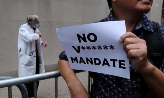 미국 뉴욕의 어느 병원 앞에서 한 남성(오른쪽)이 ‘백신 접종 의무화 반대’가 적힌 종이를 든 채 시위하고 있다. 세계일보 자료사진