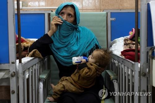 아프간 카불의 한 병원에서 아이를 안고 있는 여성  [로이터 연합뉴스 자료사진. 재판매 및 DB 금지. 기사 내용과는 직접 상관없는 사진임.]