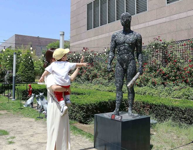 신세계 강남점 고객이 옥상정원에 설치된 미술 작품을 감상하고 있다.
