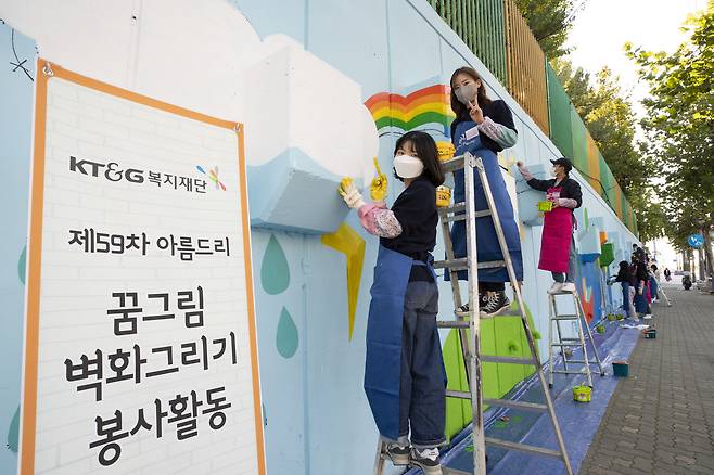 KT&G 복지재단이 대학생 자원봉사자 약 70여명과 서울양원초등학교 담장 벽화 봉사를 진행하고 있다.(KT&G 제공)© 뉴스1