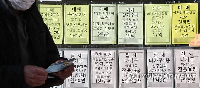 (서울=연합뉴스) 황광모 기자 = 지난 25일 오전 서울 서대문구의 부동산 중개업소에 게시된 매물 가격 안내판 앞을 한 시민이 은행 통장을 든 채 지나가고 있다.
 2021.10.25 hkmpooh@yna.co.kr