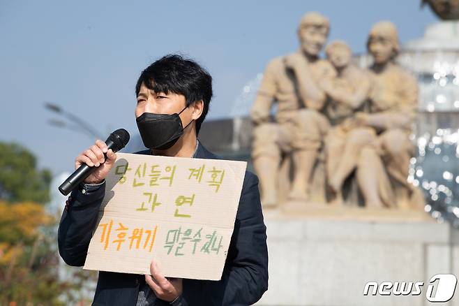 기후위기비상행동과 유엔기후변화협약 제26차 당사국총회(COP26) 참가단이 27일 서울 청와대 분수대 앞에서 기자회견을 열고 한국정부가 확정한 2030 온실가스 감축목표를 규탄하고 기후정의 실천을 위한 시민사회 입장을 밝히고 있다. 이들은 대통령 산하 탄소중립위원회가 의결한 온실가스 감축목표치가 기후정의를 실현하기에는 너무나 낮은 목표치라며, 온실가스 감축목표 상향을 요구했다. 2021.10.27/뉴스1 © News1 유승관 기자