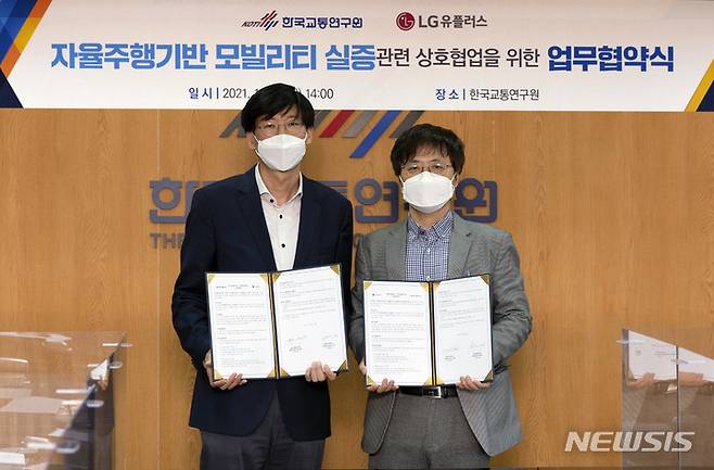 [서울=뉴시스]LG유플러스는 한국교통연구원과 자율주행기반모빌리티 서비스 실증사업을 수행하기 위한 업무협약을 맺었다고 28일 밝혔다. 사진은 세종특별자치시 국교통연구원에서 열린 협약식에서 주영준 LG유플러스 차세대기술랩장(왼쪽)과 장원재 종합교통연구본부장이 기념촬영을 하고 있는 모습. (사진=LG유플러스 제공)