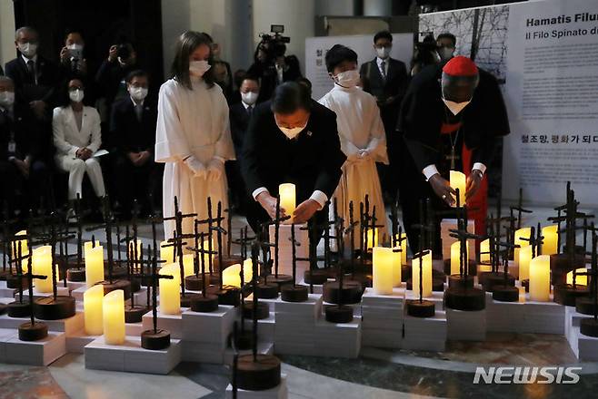 [로마=뉴시스] 김진아 기자 = 문재인 대통령이 29일(현지시간) 이탈리아 로마 산티냐시오 디 로욜라 성당에서 열린 ‘철조망 평화가 되다’ 전시회에서 피터 턱슨 추기경과 한반도를 형상화한 전시작품의 LED 촛불 점등식을 하고 있다. 2021.10.29. bluesoda@newsis.com