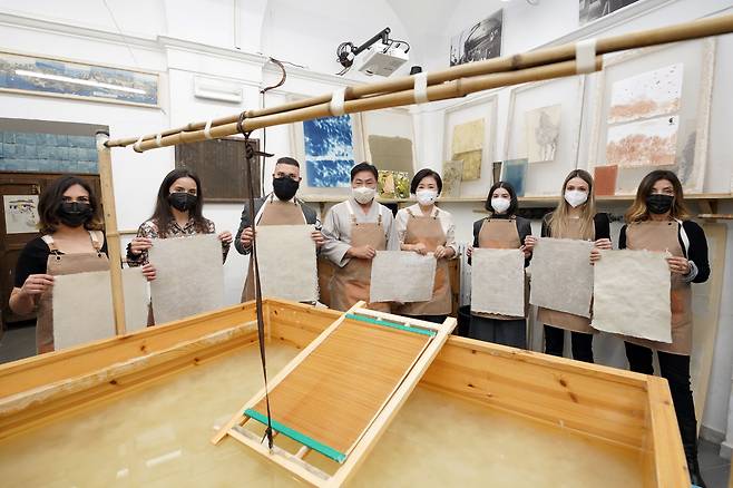 김정숙 여사가 30일 오후(현지 시각) 국립로마미술대학에서 한지 제작 실습을 마친 뒤 국가무형문화재 한지장 보유자 안치용 장인을 비롯한 미술대 학생들과 기념촬영을 하고 있다. /연합뉴스