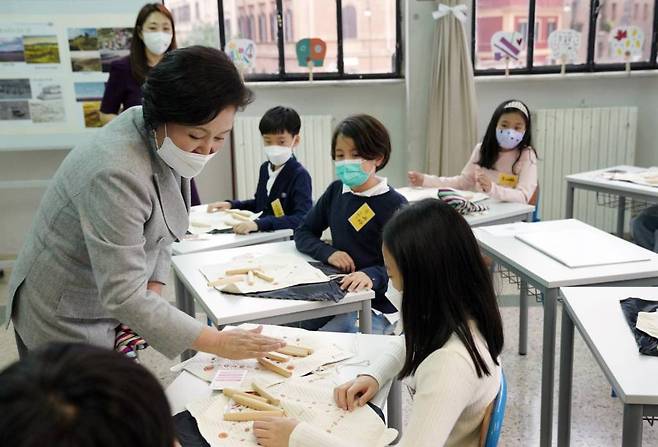 [로마=뉴시스] 김진아 기자 = 김정숙 여사가 31일(현지시간) 이탈리아 로마한글학교에서 역사·문화 수업 참관 후 학생들에게 선물한 윷놀이 방법을 설명하고 있다. 2021.11.01.