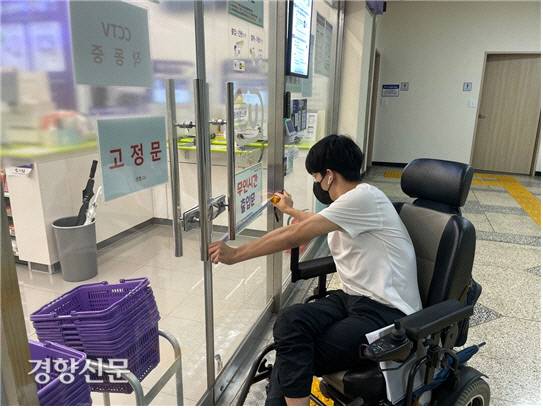 제주장애인인권포럼 모니터링 단원이 제주의 한 편의점 주출입구의 유효폭을 측정하고 있다. 제주장애인인권포럼 제공