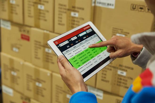 CJ대한통운 직원이 모바일 앱을 통해 물류센터 현황을 파악하고 있다. CJ대한통운 제공