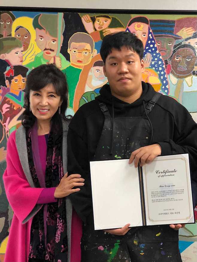 Kay Song (left) and Shin Dong-min smile for the camera at a donation ceremony on Tuesday.