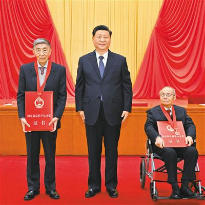 시진핑(가운데) 중국 국가주석이 3일 베이징 인민대회당에서 열린 ‘2020년도 국가 과학기술 장려대회’에서 국가최고과학기술상’ 수상자로 선정된 전투기 디자이너 구쑹펀(오른쪽), 신형 원전 전문가 왕다중과 기념 사진을 하고 있다./인민일보 캡처