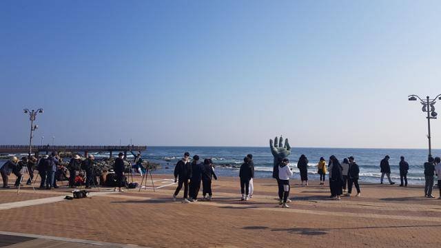 경북 포항 호미곶을 찾은 여행객들이 지난 2일 조형물 '상생의 손'이 있는 해맞이광장에서 주변 풍광을 감상하며 사진을 찍고 있다. 김정혜 기자