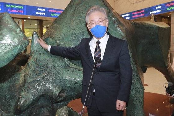 이재명 더불어민주당 대선후보가 4일 서울 여의도 한국거래소에서 열린 주식시장 발전과 개인투자자 보호를 위한 간담회를 앞두고 증시 활황을 의미하는 황소 동상 앞에서 포즈를 취하고 있다. [국회사진기자단]