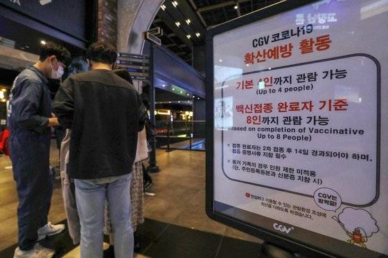 정부가 2022년 1월까지 총 세 차례에 걸쳐 '단계적 일상 회복(위드 코로나·with covid19·코로나와 공존)'을 위한 방역 완화를 추진한다.   중대본에 따르면 오는 11월 1일부터 영화관을 찾은 관객들은 심야영화를 볼 수 있으며, 시범사업 형태지만 상영관에서 팝콘과 음료도 먹을 수 있게 된다.   29일 서울의 한 멀티플렉스 영화관의 상영관 입구에 코로나19 백신접종 완료자를 기준으로한 관람 가능인원이 안내되고 있다. 뉴스1