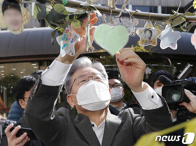 이재명 더불어민주당 대선 후보가 7일 서울 강서구 공립 지적장애 특수학교인 서진학교를 방문해 응원 메시지를 적어 나무에 매달고 있다. 2021.11.7/뉴스1 © News1 구윤성 기자