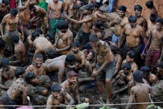 지난 6일 인도 카르나타카주 벵갈루루 인근서 개최된 '고레 하바' 축제에서 참가자들이 소똥을 몸에 바르고 있다. AFP=연합뉴스