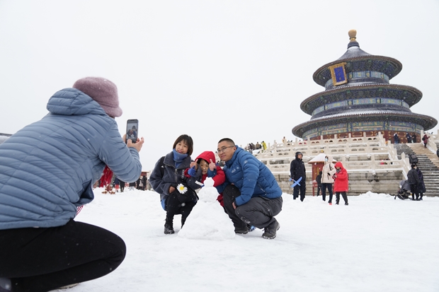 7일 베이징 천단공원에서 관광객들이 눈사람을 배경으로 사진을 찍고 있다./신화통신 연합뉴스