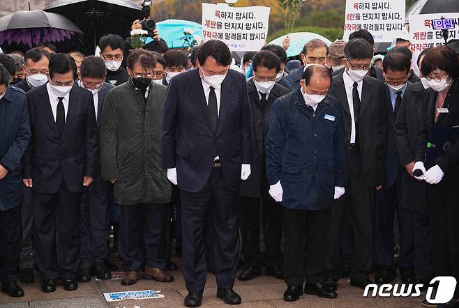 윤석열 국민의힘 대선 후보가 10일 광주 북구 국립 5·18 민주묘지에서 방문을 항의하는 시민들에게 막혀 참배단까지 가지 못한 채 도중에 멈춰 서 참배하고 있다. 2021.11.10/뉴스1 © News1 이동해 기자