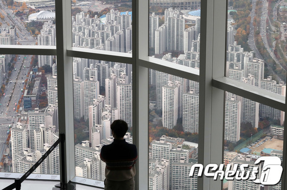 10일 서울 송파구 롯데월드 서울스카이 전망대를 찾은 관람객이 아파트단지가 밀집한 서울시내를 바라보고 있다. 기사와 무관. (서울=뉴스1) 박세연 기자© 뉴스1