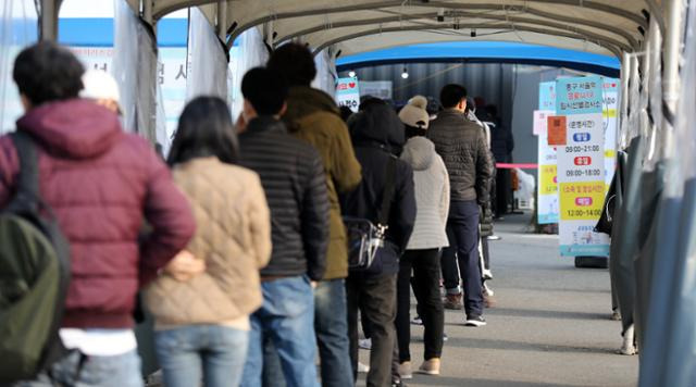 14일 서울 중구 서울역광장에 마련된 신종 코로나바이러스 감염증(코로나19) 임시 선별검사소를 찾은 시민들이 검사를 위해 줄 서 있다. 뉴스1