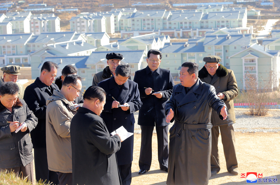 Clad in a black trench coat, Kim Jong-un provides on-the-spot guidance at the site of the urban development in Samjiyon in North Korea's Ryanggang Province. The report of the visit was released by the North's state-controlled Korean Central News Agency on Tuesday. [YONHAP]