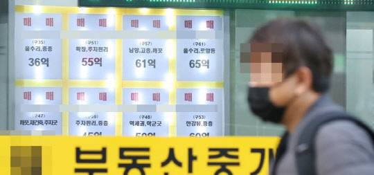 한 시민이 부동산 매물정보가 걸려있는 한 공인중개업소 앞을 지나가고 있다. <연합뉴스>