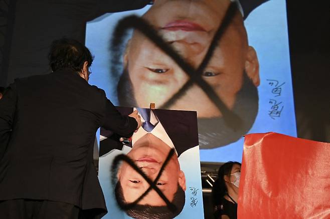 대만 독립 시위대가 시진핑 중국 국가주석 사진을 거꾸로 놓고 낙서하고 있다. /사진=AFP