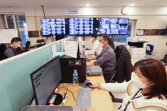 지난 18일 오후 서울 영등포구에 있는 코로나19 생활치료센터 상황실에서 운영총괄반 직원들이 모니터를 보며 실시간 상태를 확인하고 있다.사진공동취재단