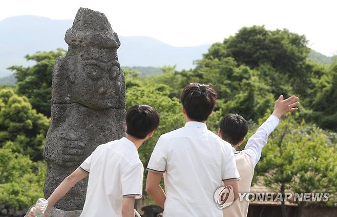 안녕! 돌하르방 (제주=연합뉴스) 수학여행으로 제주돌문화공원을 찾은 학생들이 돌하르방을 보며 손을 흔들고 있다. [연합뉴스 자료사진]