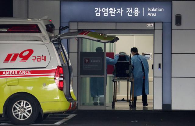 22일 오전 서울 중랑구 서울의료원 응급의료센터에서 구급 대원들이 감염환자 전용 출입문으로 환자를 이송하고 있다. 뉴시스