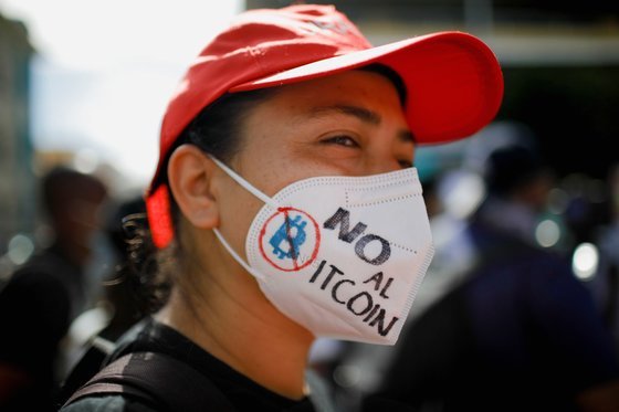 지난 9월7일(현지시간) 엘살바도르 수도 산살바도르에서 비트코인 법정통화 도입에 반대하는 시위대가 비트코인 반대 문구를 적어 놓은 마스크를 쓰고 있다. [로이터=연합뉴스]