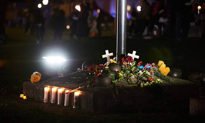 미국 위스콘신주 워키쇼에서 크리스마스 행진 대열에 차량이 돌진하는 사고가 발생한 다음 날인 22일(현지시간) 시내 커틀러 공원에 마련된 임시 추모소에 희생자들을 추모하는 촛불이 밝혀져 있다. AFP연합뉴스