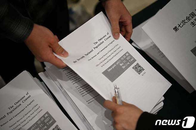 베이징의 국무원 신문판공실에서 열린 기자회견서 취재진에게 국가 통계국의 인구조사 자료를 배포되고 있다. © AFP=뉴스1 © News1 우동명 기자