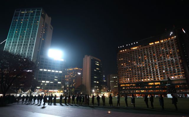 시민들이 24일 저녁 서울 중구 서울광장 코로나19 임시선별진료소에서 검사를 기다리며 길게 줄지어 서있다. 연합뉴스
