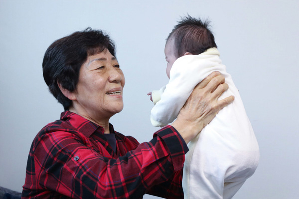 LG의인상을 수상한 위탁모 봉사자 전옥례 씨가 서울 서대문구에 위치한 자택에서 위탁아동을 돌보고 있다. [사진 제공 = LG]