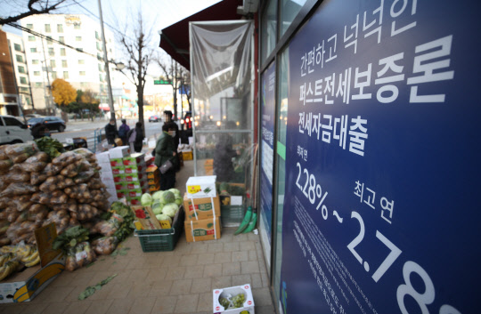 25일 기준금리가 연 1%로 인상되면서 가계 이자 부담도 늘어날 것으로 예상된다. 서울 시내 한 은행 외벽에 붙은 대출 관련 안내문. 연합뉴스