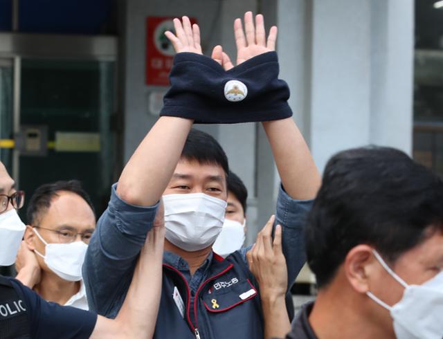 양경수 민주노총 위원장이 9월 6일 서울 종로경찰서에서 검찰로 송치되며 노조원들을 향해 손을 들고 있다. 뉴스1