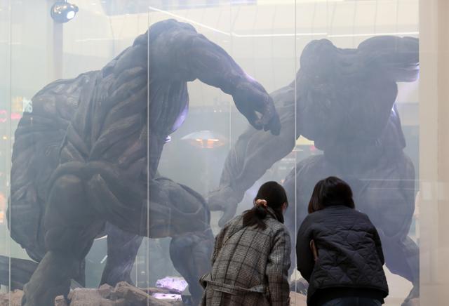24일 오후 서울 강남구 코엑스에 설치된 넷플릭스 오리지널 '지옥' 체험존을 찾은 시민들이 지옥의 사자 조형물을 둘러보고 있다. 뉴시스