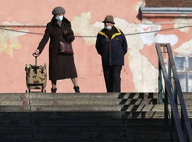 크로아티아 자그레브의 노부부가 24일 마스크를 쓰고 나들이를 하고 있다. AP=연합뉴스