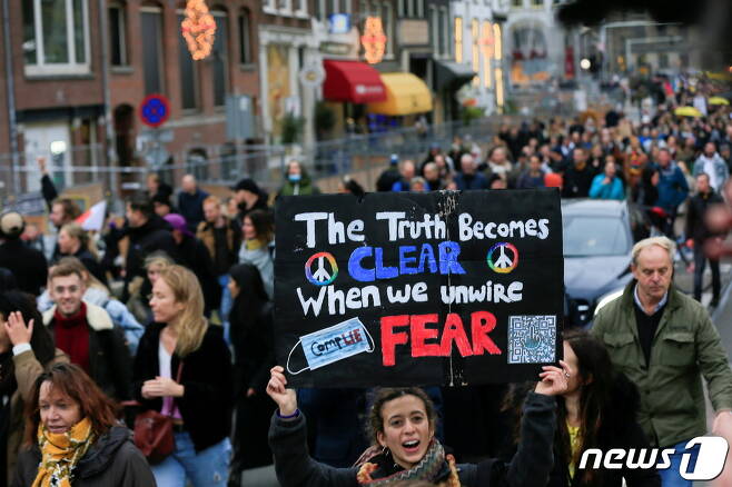네덜란드에서 지난 20일(현지시간) 정부의 코로나19 봉쇄 조치에 반대해 사람들이 거리에 모여 시위를 하고 있다. © 로이터=뉴스1 © News1 원태성 기자